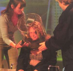 Audience member putting their head into a cage of insects